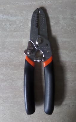 Reference image: A generic wire stripper with black and orange handles. Representative photo, not the exact model.