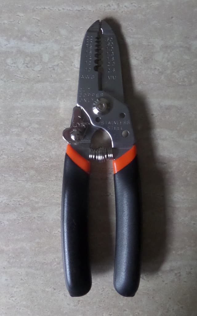 Reference image: A generic wire stripper with black and orange handles. Representative photo, not the exact model.
